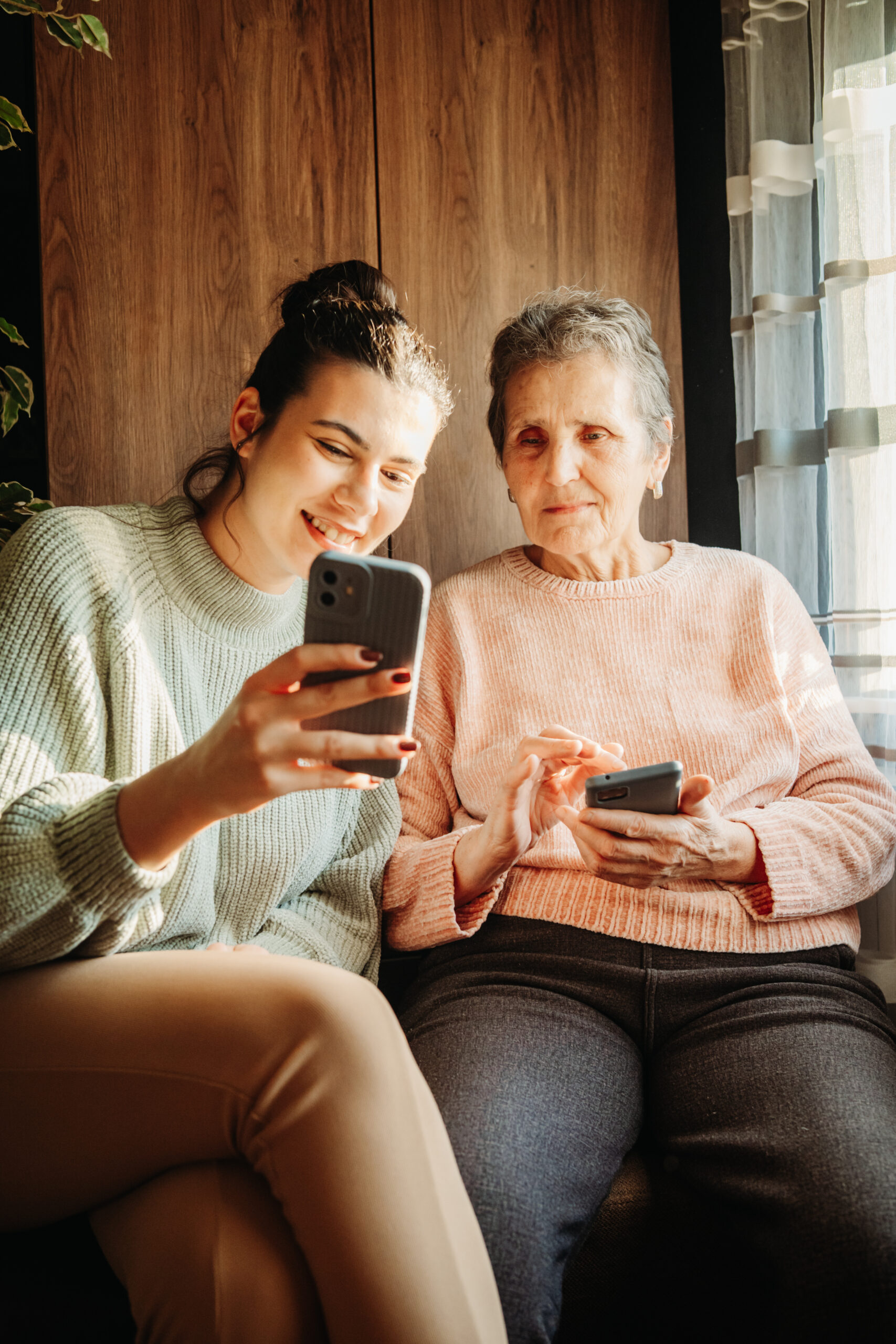 Senior woman and her granddaughter use cellphone to send text messages sms